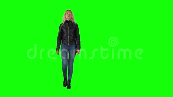 金发女孩穿着黑色皮夹克牛仔裤和靴子穿着绿色的屏幕视频的预览图