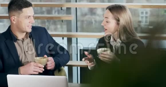 男人和女人在灯火通明的现代办公室里讨论工作男性和女性使用笔记本电脑工作喝咖啡视频的预览图