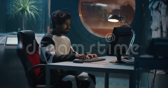 男性宇航员在电脑上工作视频的预览图