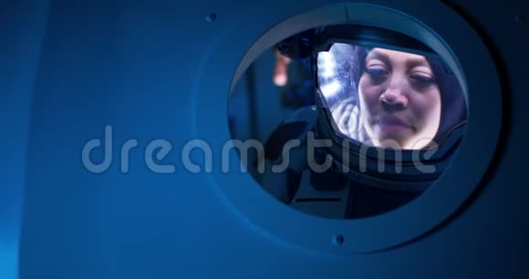 女宇航员在太空船上眺望视频的预览图