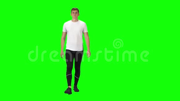 穿着白色t恤运动裤和运动鞋的年轻人穿着绿色背景视频的预览图