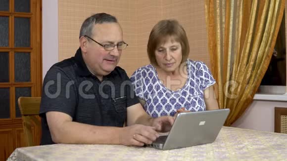 男人和女人通过笔记本电脑通过视频交流与朋友交流一个老男人和一个老女人视频的预览图