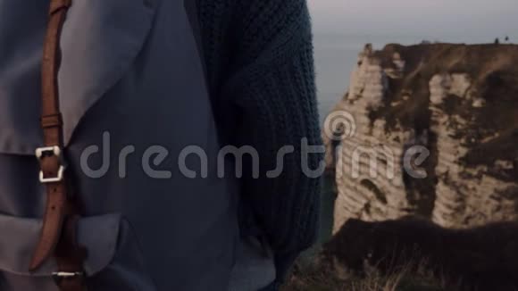 超级特写女游客背着背包观看雄伟的粉红色日落海悬崖全景埃特雷特慢动作视频的预览图
