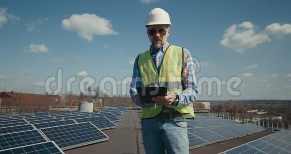 工程师在太阳能电池板之间使用平板电脑视频的预览图