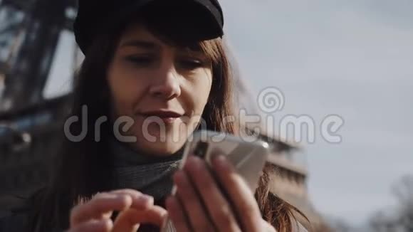 美丽的年轻女商人使用智能手机购物应用程序的肖像微笑着看阳光明媚的巴黎埃菲尔铁塔慢动作视频的预览图