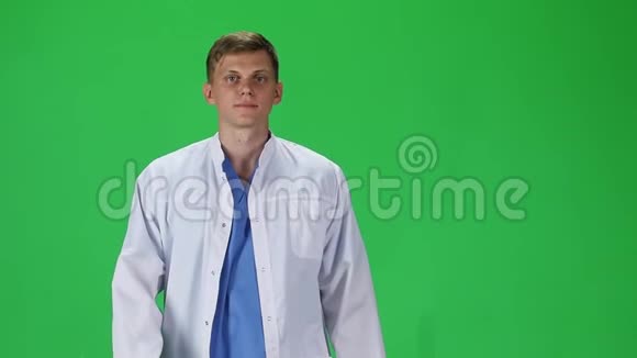 穿着白大褂的医务人员在绿色的背景下向前看慢动作视频的预览图