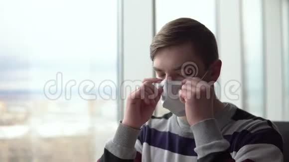 一个年轻人脱下医疗面具吃了一个汉堡然后戴上面具一个男人坐在窗边的咖啡馆里视频的预览图