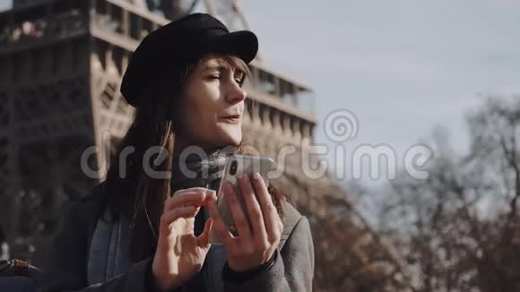 迷人的年轻欧洲女商人使用智能手机移动办公应用程序在巴黎埃菲尔铁塔思考慢动作视频的预览图