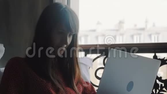 自由工作理念快乐美丽微笑的白种人作家女性在床上使用笔记本电脑度假慢动作视频的预览图