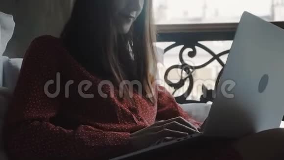 自由职业概念特写在快乐美丽的黑发女商人使用笔记本电脑在床上度假慢动作视频的预览图