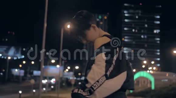 在摩天大楼的背景下韩国女孩晚上在街上摆姿势视频的预览图