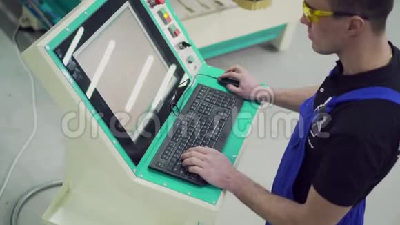 一名男性数控机床操作员正在控制面板上打字视频的预览图
