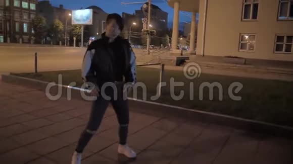非常时尚的亚洲女孩晚上在城市街道上跳舞令人印象深刻的韩国女孩视频的预览图