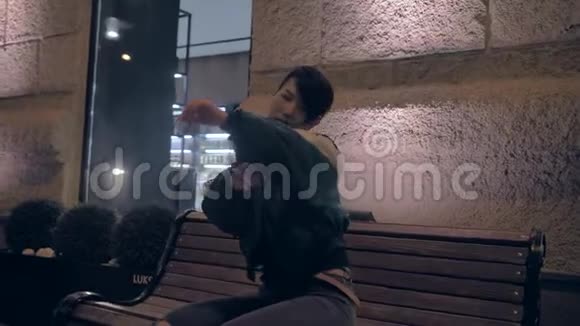 韩国女孩晚上坐在长凳上享受音乐感受氛围视频的预览图