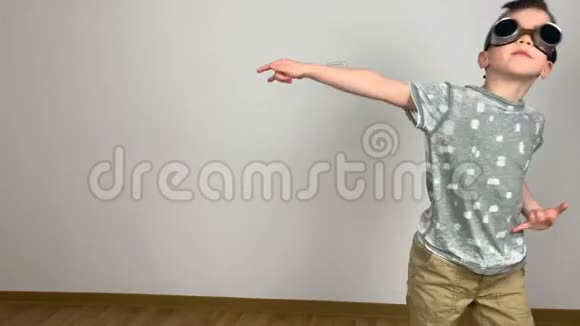 戴眼镜的小男孩无私地跳着滑稽的舞蹈和傻瓜在周围创造性的概念视频的预览图