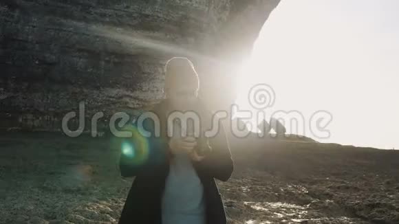 兴奋的男性摄影师拍摄惊人的岩石诺曼底海滩附近阳光明媚的埃特雷特海滨悬崖慢动作视频的预览图