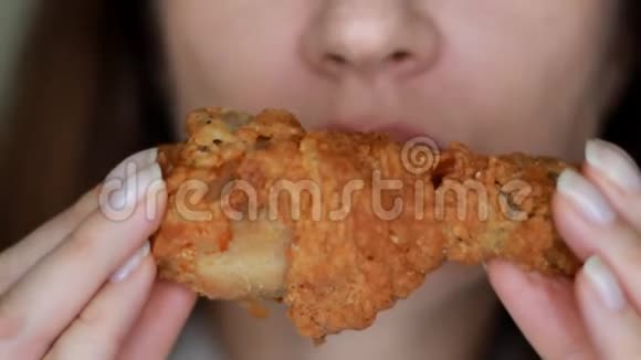 饥饿的女人吃鸡肉口和食物特写女性手中的快餐选择性重点视频的预览图