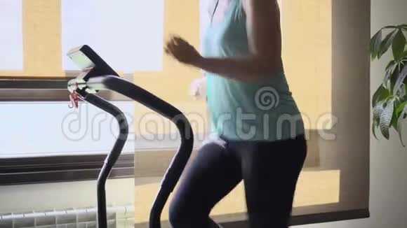 女人在客厅的跑步机上锻炼健康生活理念视频的预览图