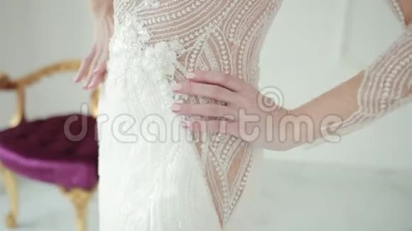 双手触摸一件漂亮的白色婚纱的腰部抚摸这条线视频的预览图