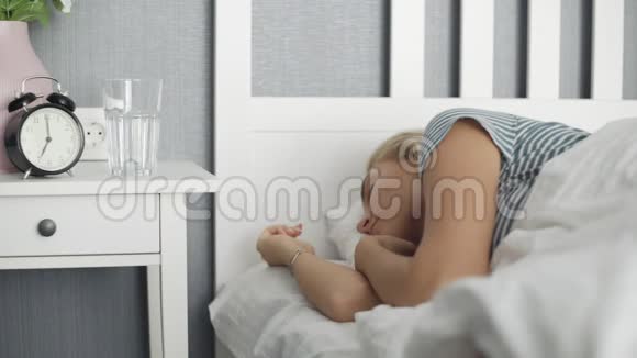 女人在白床上醒来在卧室里喝水视频的预览图