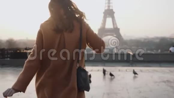 后景快乐旅游女跑到雾蒙蒙的日出埃菲尔铁塔观巴黎浪漫度假之旅慢动作视频的预览图