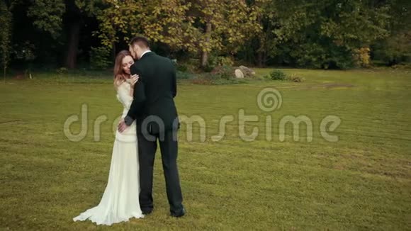 一对新婚夫妇拥抱新郎用嘴唇抚摸头发新娘闭上眼睛视频的预览图
