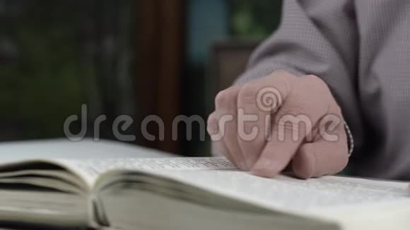 穿着格子衬衫的老人看书用手指视频的预览图