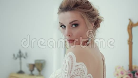 身着白色婚纱的年轻金发新娘的特写镜头在镜头前视频的预览图