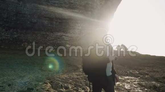 在阳光明媚的Etretat海滨慢镜头下背光的快乐男性摄影师拍摄了令人叹为观止的诺曼底岩石悬崖视频的预览图