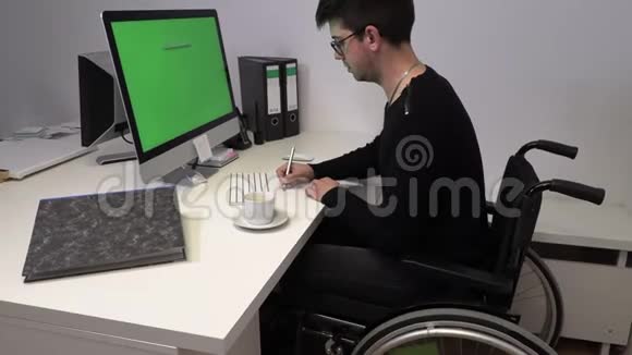 坐轮椅的经理一个不能在工作场所用电脑走路的年轻人动作慢视频的预览图