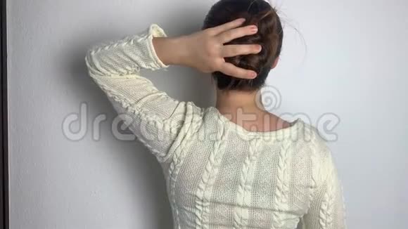 穿着白色连衣裙的欧洲年轻女孩在家里梳着她天然的长发理顺了头发护理的概念视频的预览图
