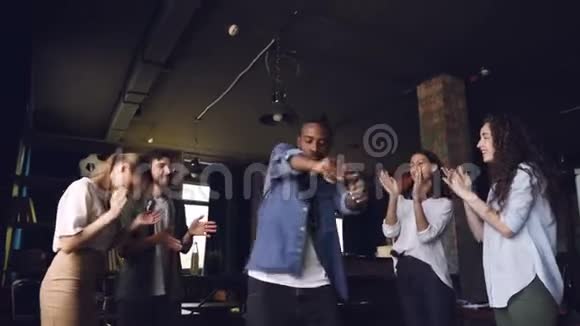 快乐的上班族非裔美国人在公司聚会上跳舞而他的团队成员在鼓掌视频的预览图