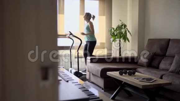 女人在客厅的跑步机上锻炼健康生活理念视频的预览图
