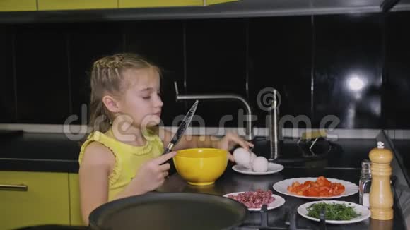 聪明的女孩学做饭年轻的女主人孩子们用咸肉煎蛋卷做一个那不勒斯鸡蛋煎蛋卷视频的预览图