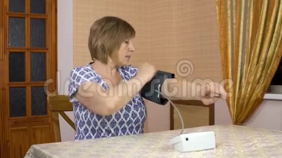 女人用一个装置来测量心脏压力一位老年妇女将血压监测仪放在手上并测量视频的预览图