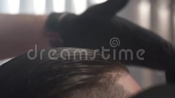 理发店的专业理发师用梳子把客户的头发梳成极端的特写镜头视频的预览图
