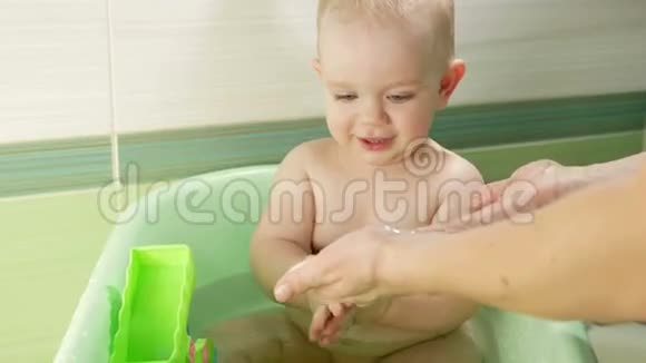 快乐宝宝洗澡玩泡沫泡泡妈妈给小男孩洗衣服小孩子在浴缸里微笑的孩子视频的预览图