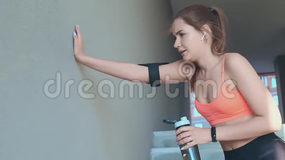 跑步后穿橙色上衣的贴身女士喝水视频的预览图