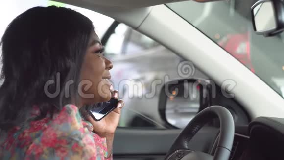 非裔美国女商人在一个大型商业论坛上坐在车里打电话车是白色的视频的预览图