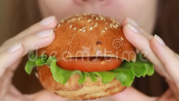 闭上女嘴咬一个汉堡吃汉堡的女人视频的预览图