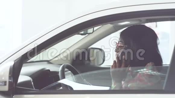 非裔美国妇女坐在车里打电话车是白色的视频的预览图