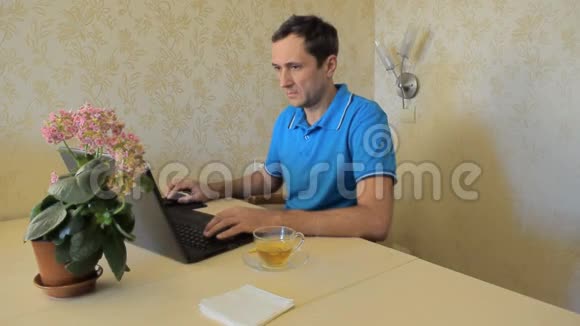 这个人在笔记本上做笔记在家里在电脑上工作而不离开家视频的预览图