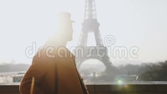 镜头跟随快乐的当地博客女性走着在雄伟的巴黎埃菲尔铁塔附近摆姿势微笑着看镜头慢动作视频的预览图