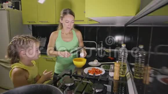 妈妈教女儿聪明的女孩学做饭米斯特雷斯的孩子们从一个那不勒斯鸡蛋煎煎蛋卷视频的预览图