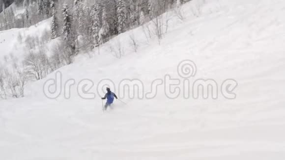 滑雪者在冬季度假胜地的雪坡上乘坐自由滑雪道在雪场的山坡上驾驶的空中观景滑雪者视频的预览图