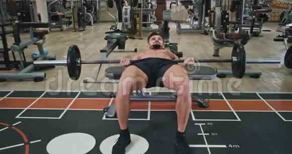 在现代的体育课上男子锻炼以获得更多的肌肉他非常集中地做他的运动视频的预览图