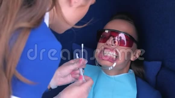 护士应用凝胶对牙科女性患者牙齿进行LED美白视频的预览图