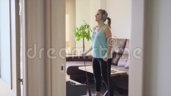 女人在家里的客厅里用弹性带做运动健康生活理念视频的预览图