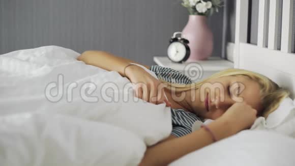 女人在卧室的白色床上醒来伸展身体视频的预览图