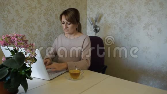 这位年轻女子在家里用电脑工作但没有离开家视频的预览图